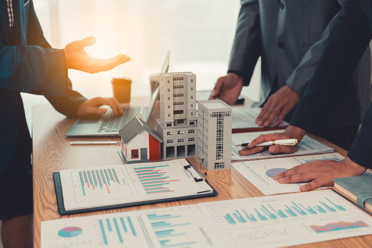 Mortgage loan officer reviewing loan documents with a couple at a closing meeting