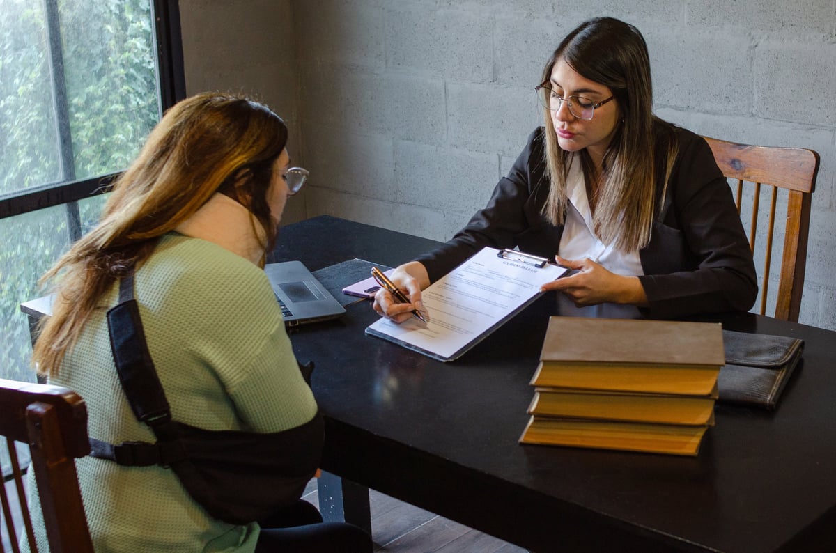 Two attorneys in suits meeting with a client at a conference table